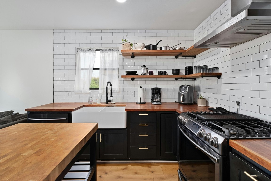 a kitchen with stainless steel appliances a sink dishwasher stove and white cabinets