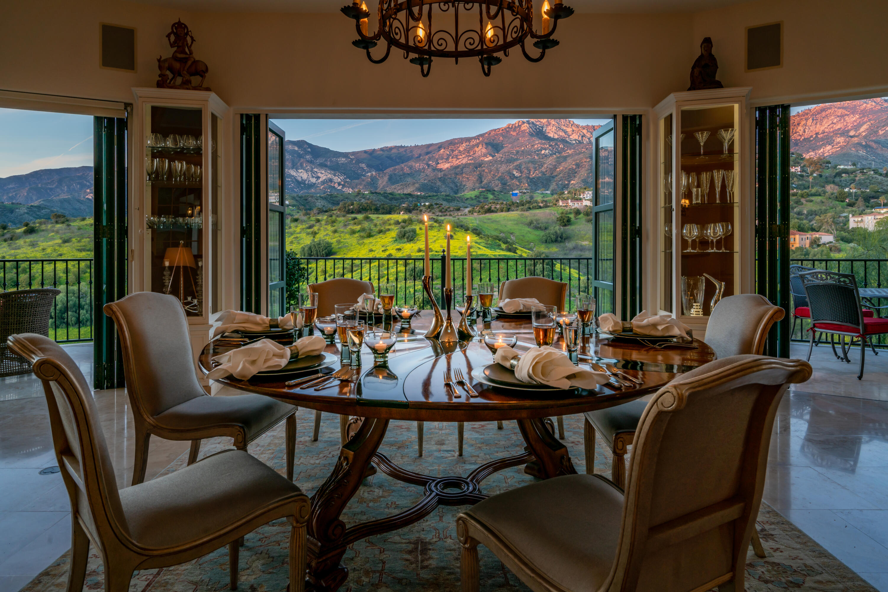 a view of a dining room with furniture large windows and a chandelier