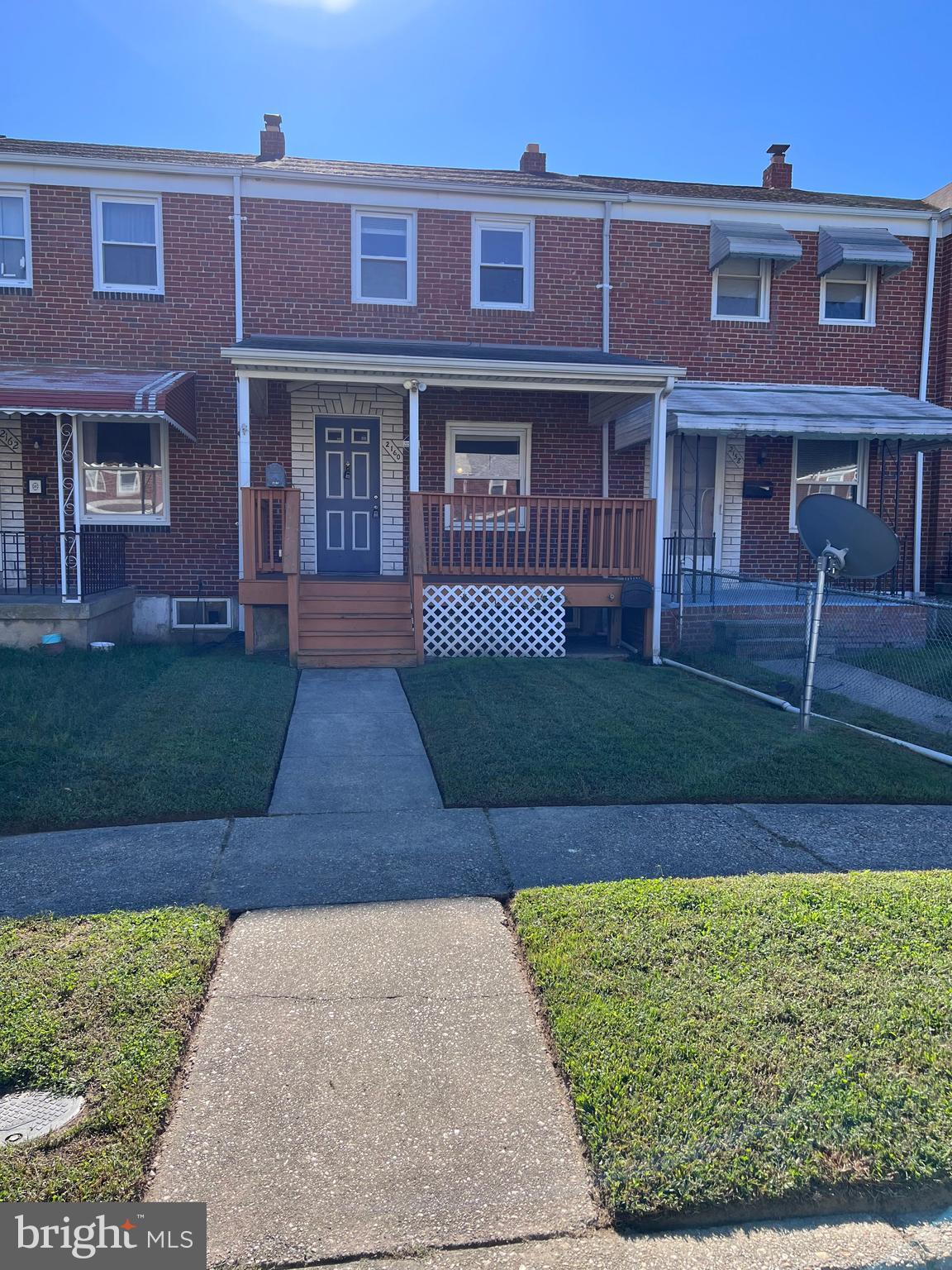 front view of a brick house with a yard