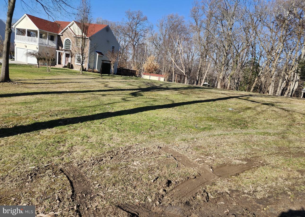 a view of a house with a big yard and large trees