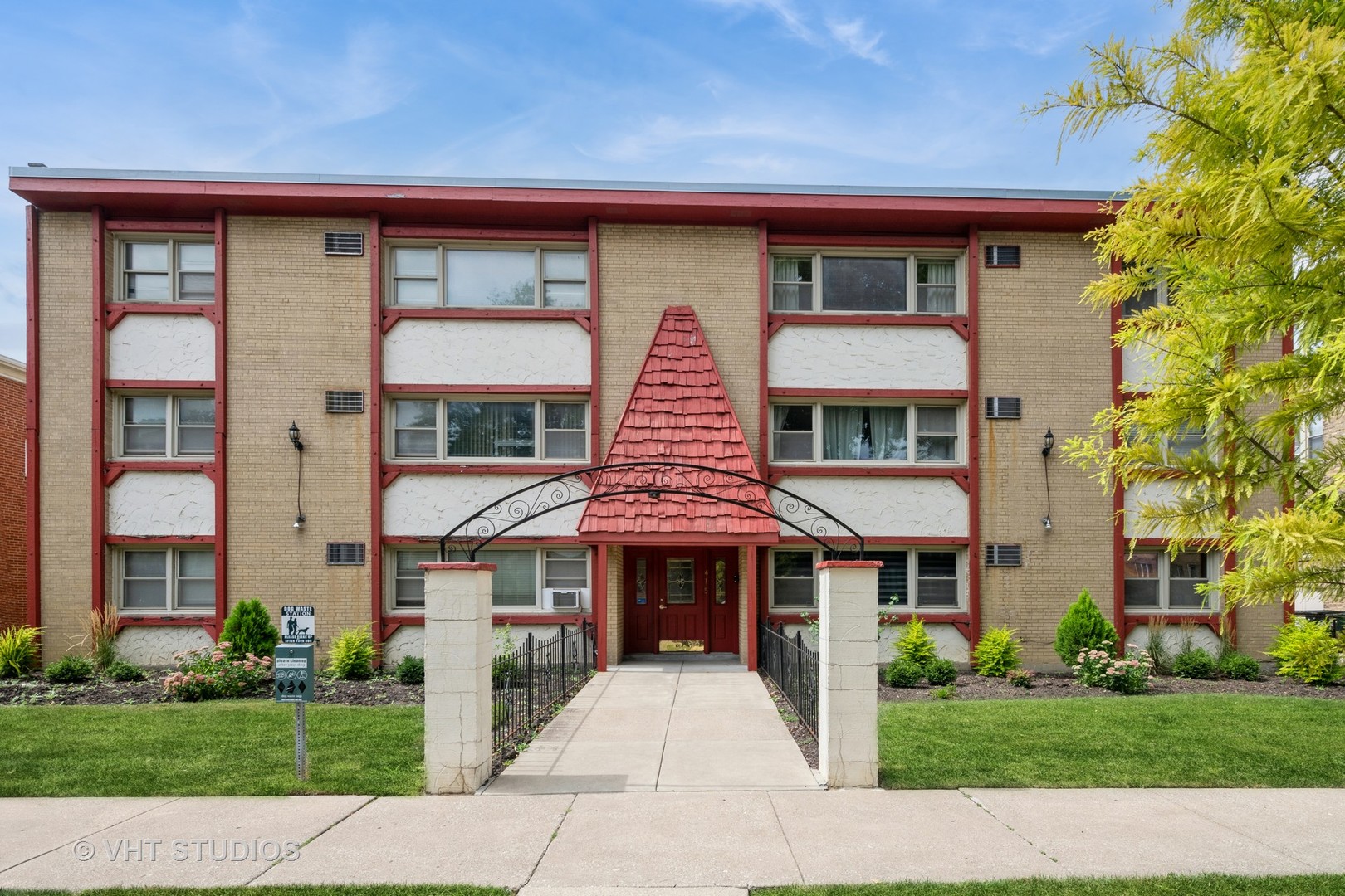 a front view of a residential apartment building with a yard