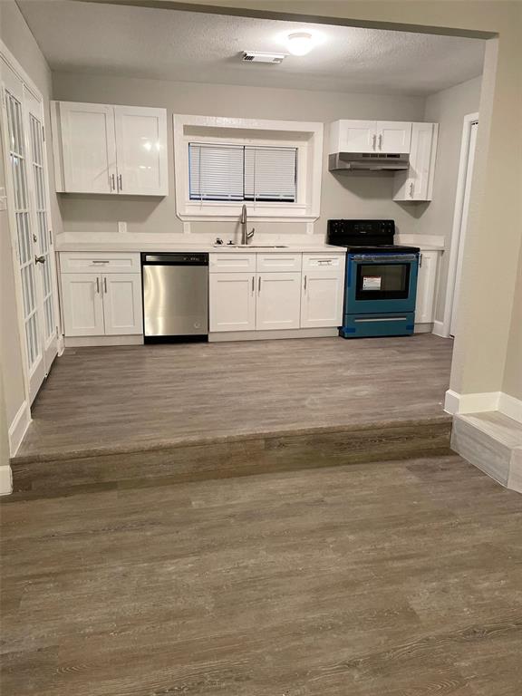 a view of kitchen with stainless steel appliances granite countertop a stove and a sink