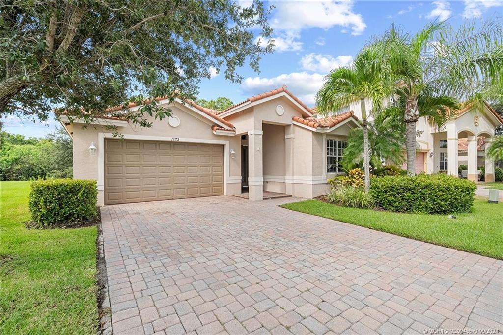 a front view of a house with a yard and garage