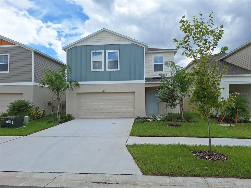 a front view of a house with a yard and a garage