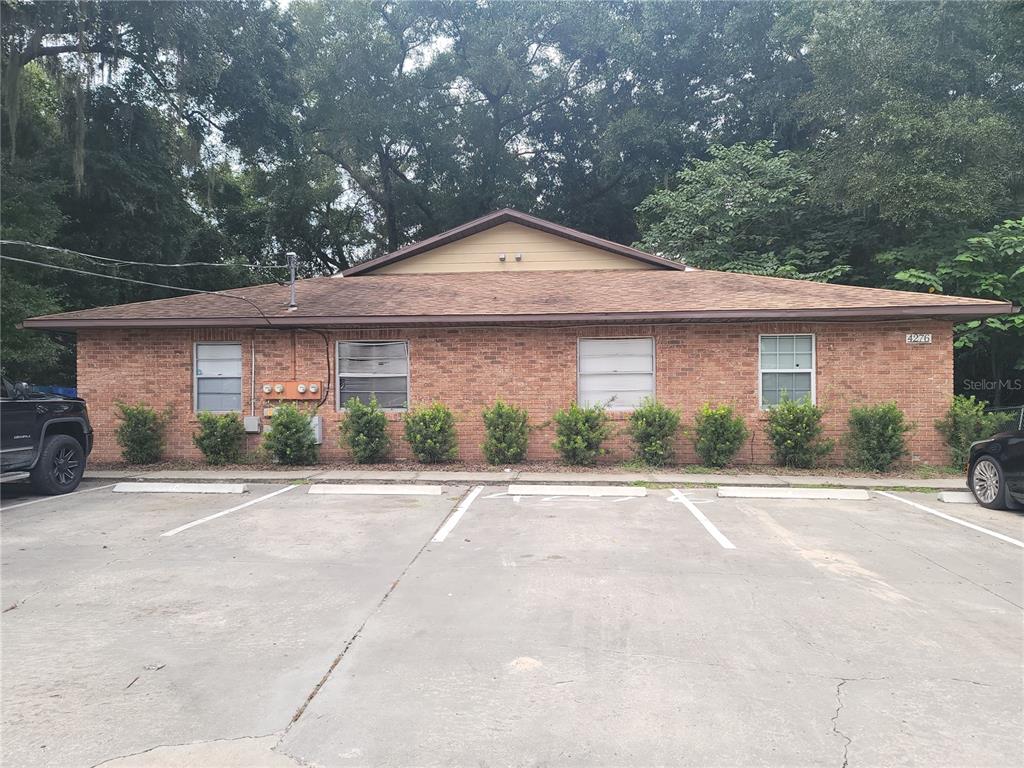 front view of house with a yard and trees around