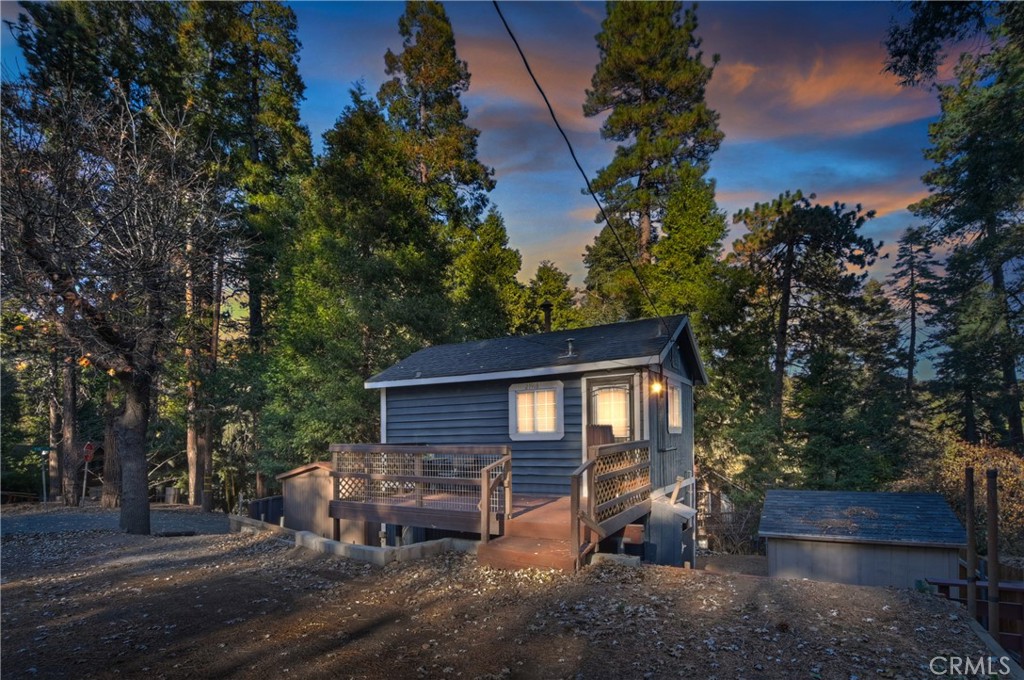 a backyard of a house with wooden fence and large trees