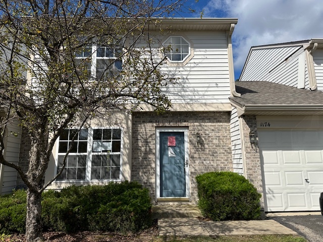 a front view of a house with plants