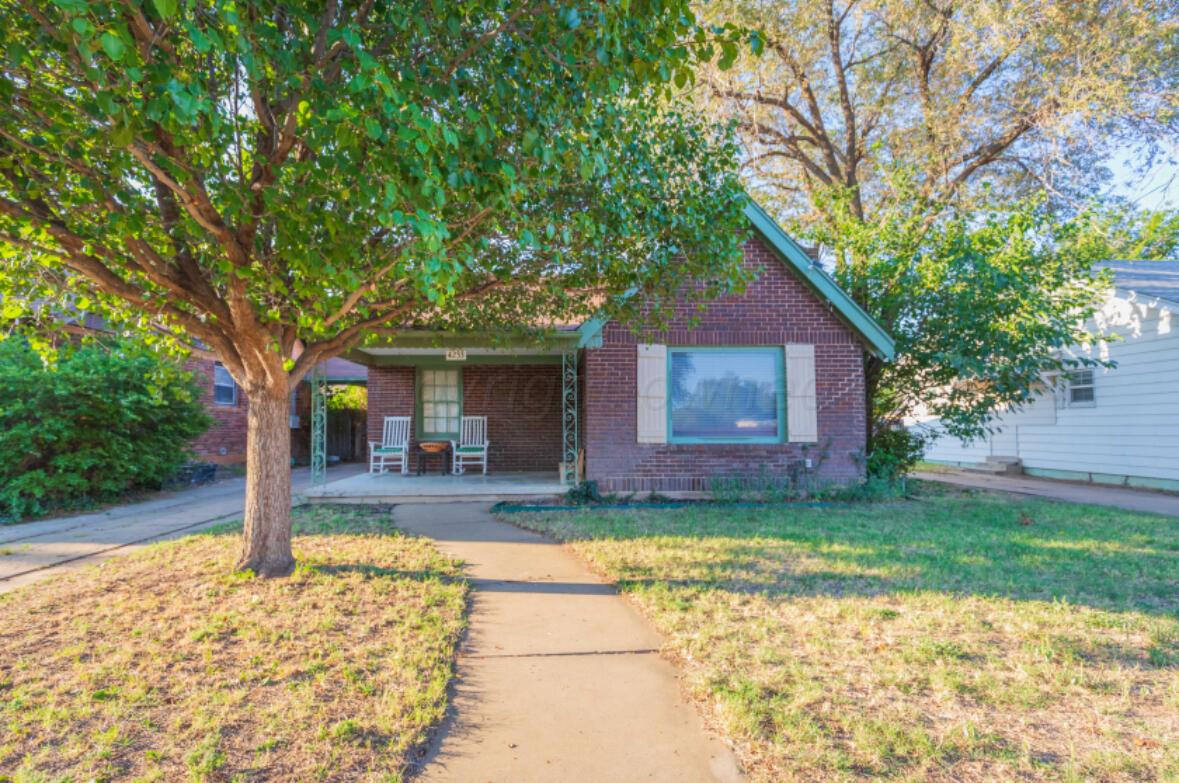 a view of a house with a yard and tree s