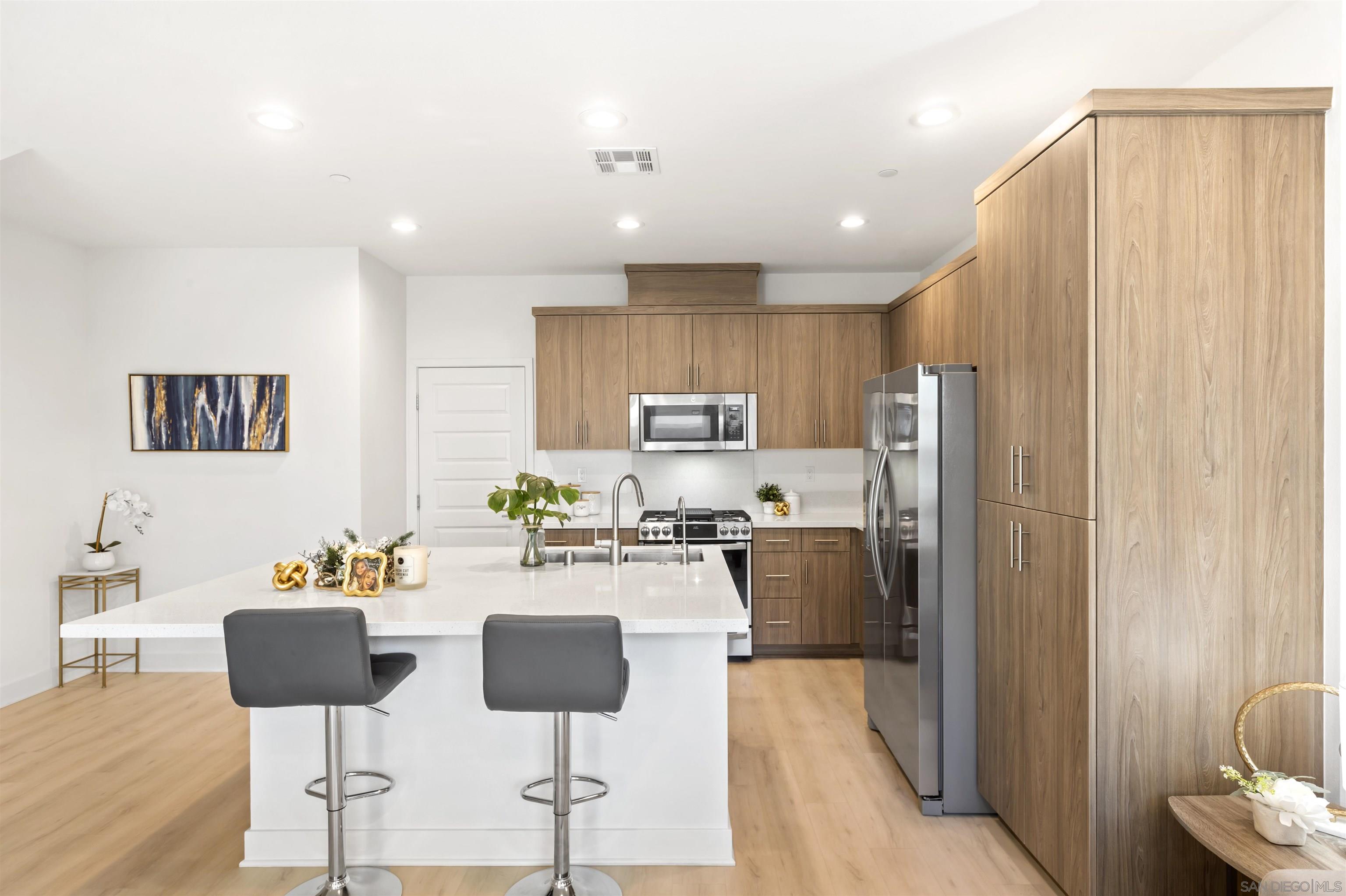 a kitchen with stainless steel appliances granite countertop a refrigerator and microwave