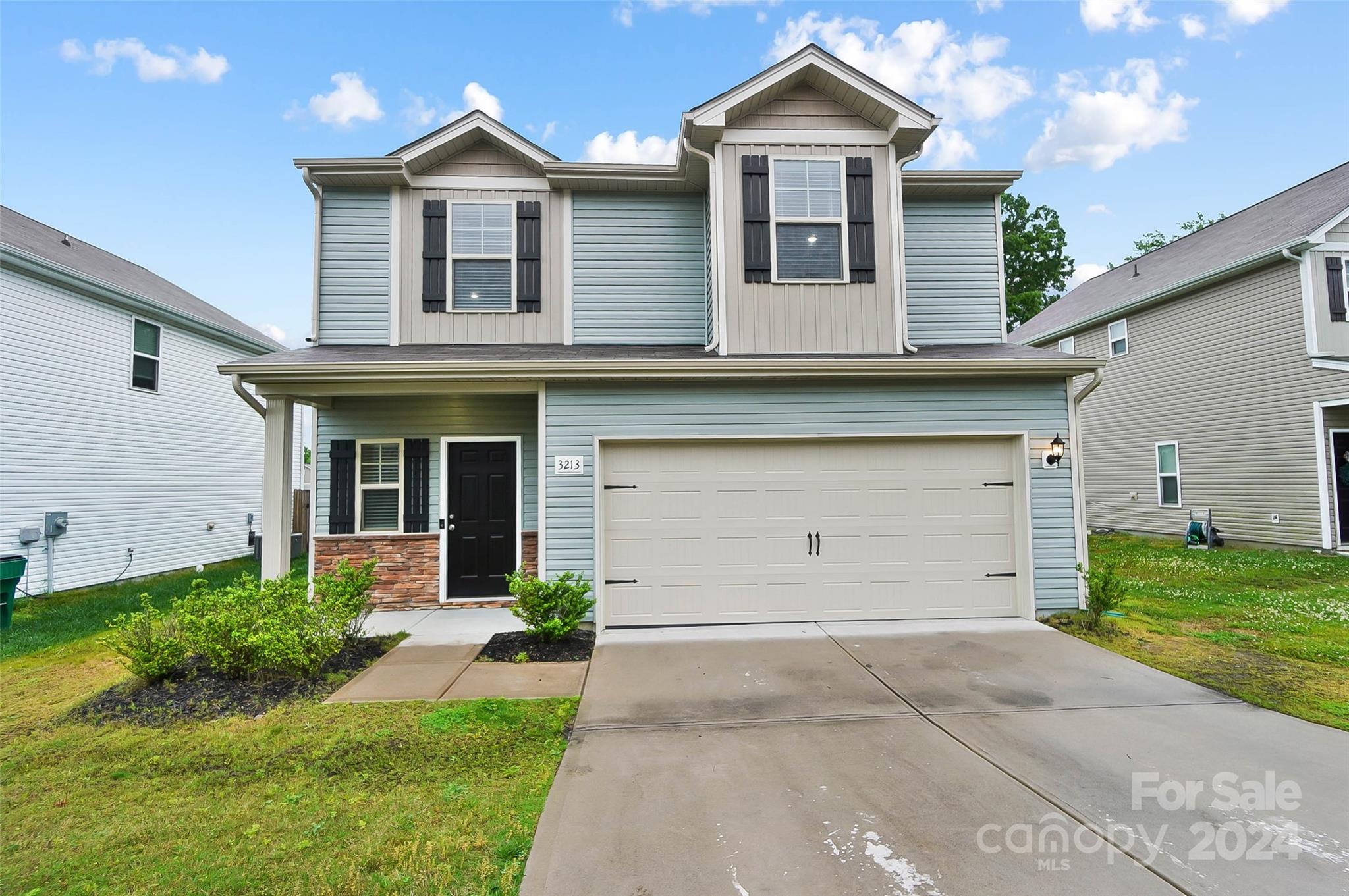 a front view of a house with a yard and garage