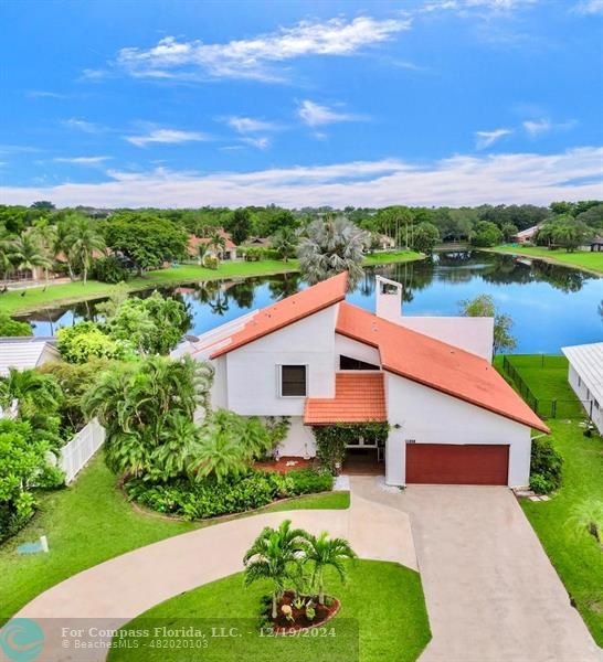 a aerial view of a house with a yard and lake view