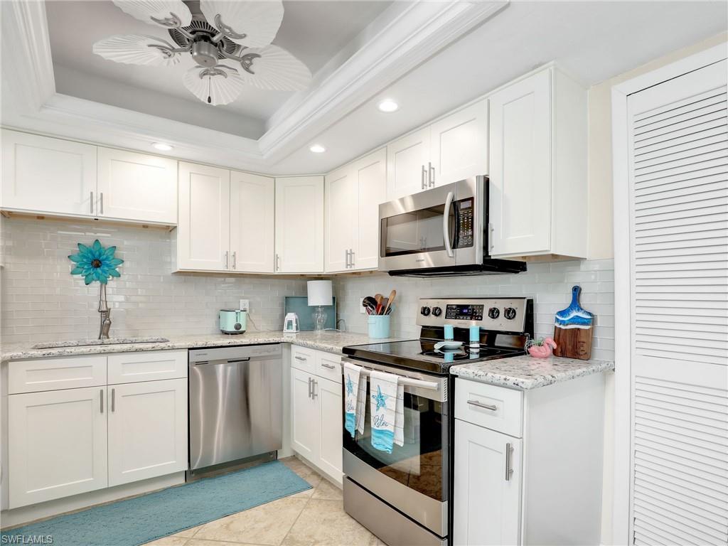 a kitchen with a sink stainless steel appliances and white cabinets