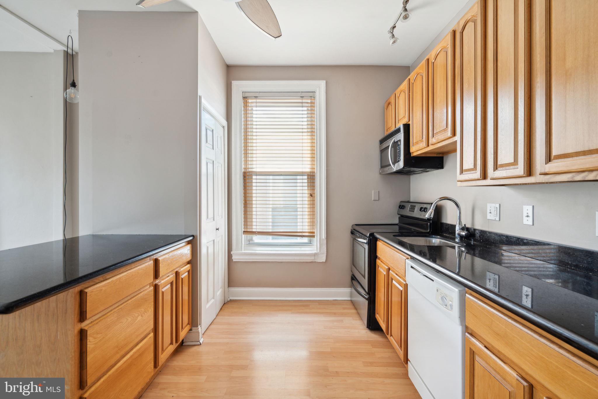 a kitchen with stainless steel appliances granite countertop a sink a stove and a refrigerator