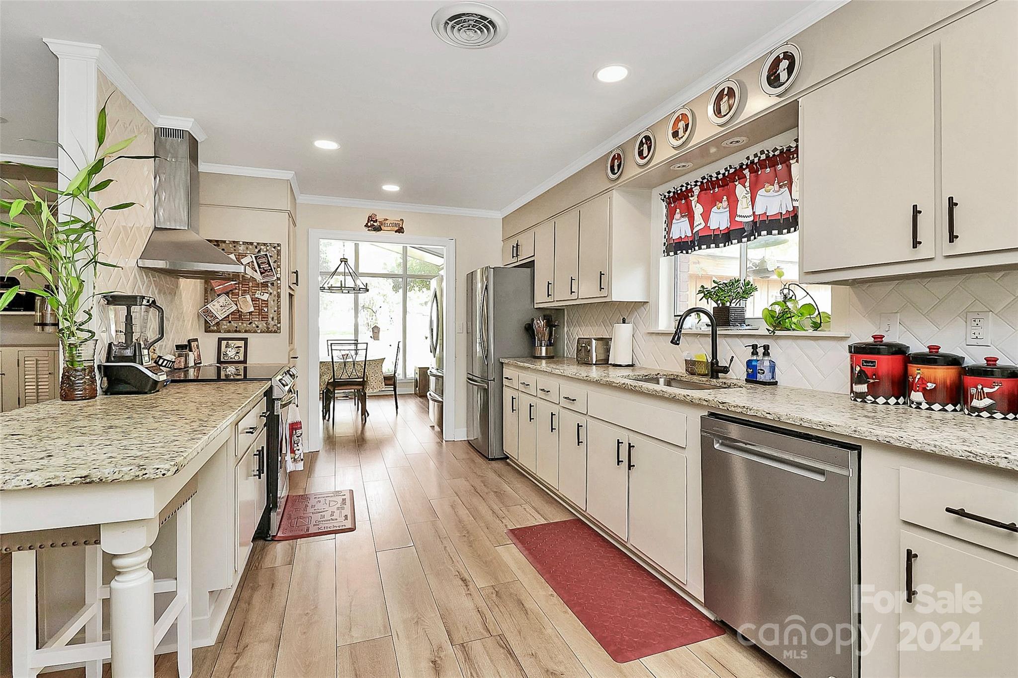 a kitchen with stainless steel appliances granite countertop lots of counter top space and wooden floor