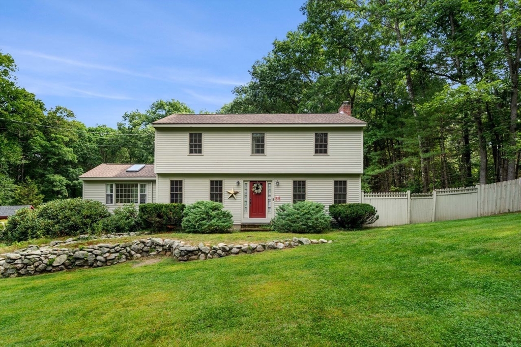 a front view of a house with a yard and potted plants