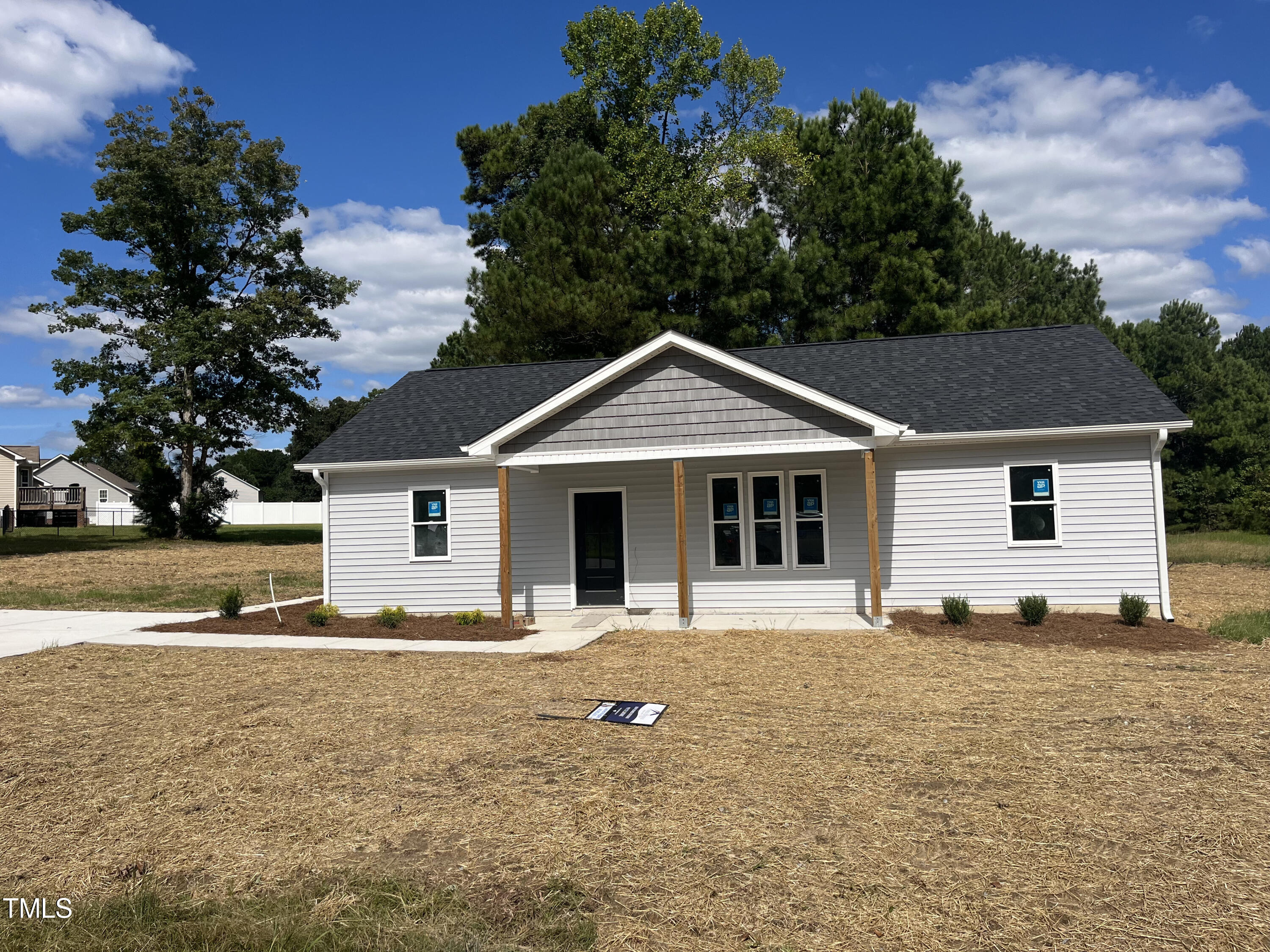 a front view of house with yard and trees around