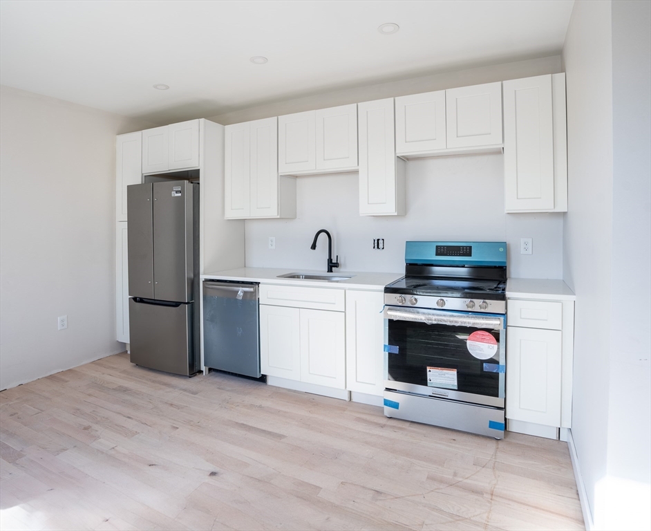 a kitchen with stainless steel appliances a stove microwave and sink