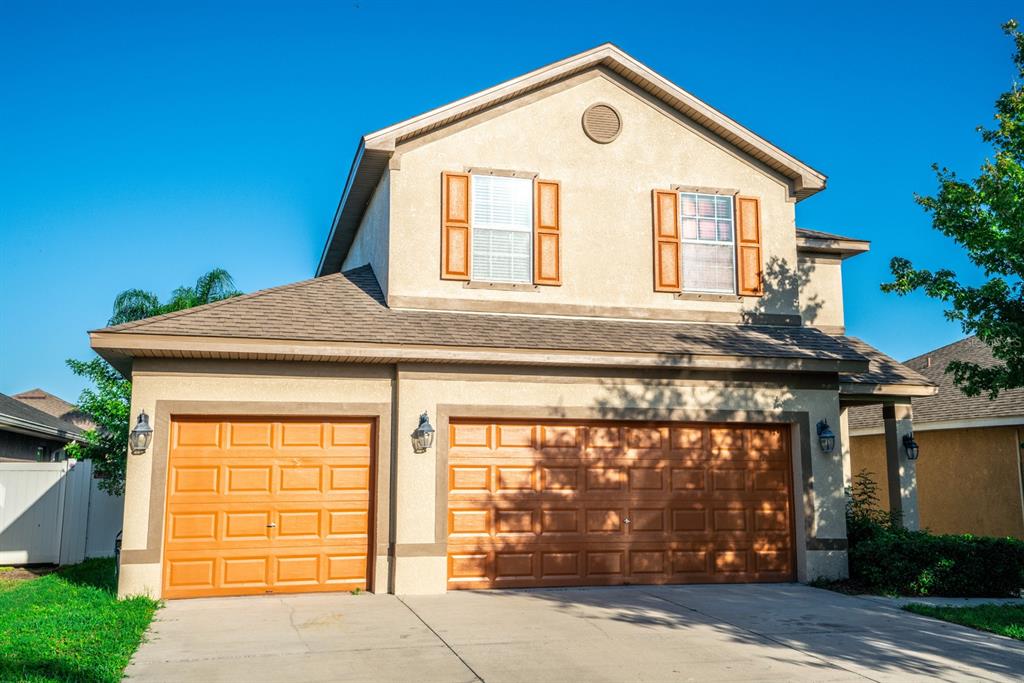 a view of a house with a garage and balcony