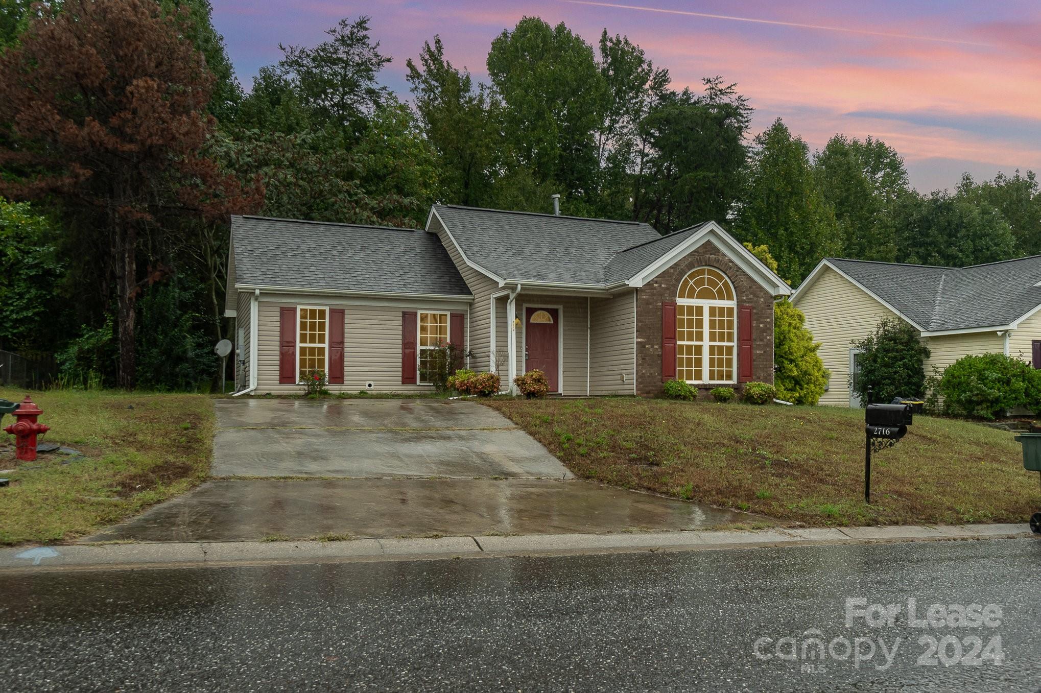 a front view of a house with a yard and trees