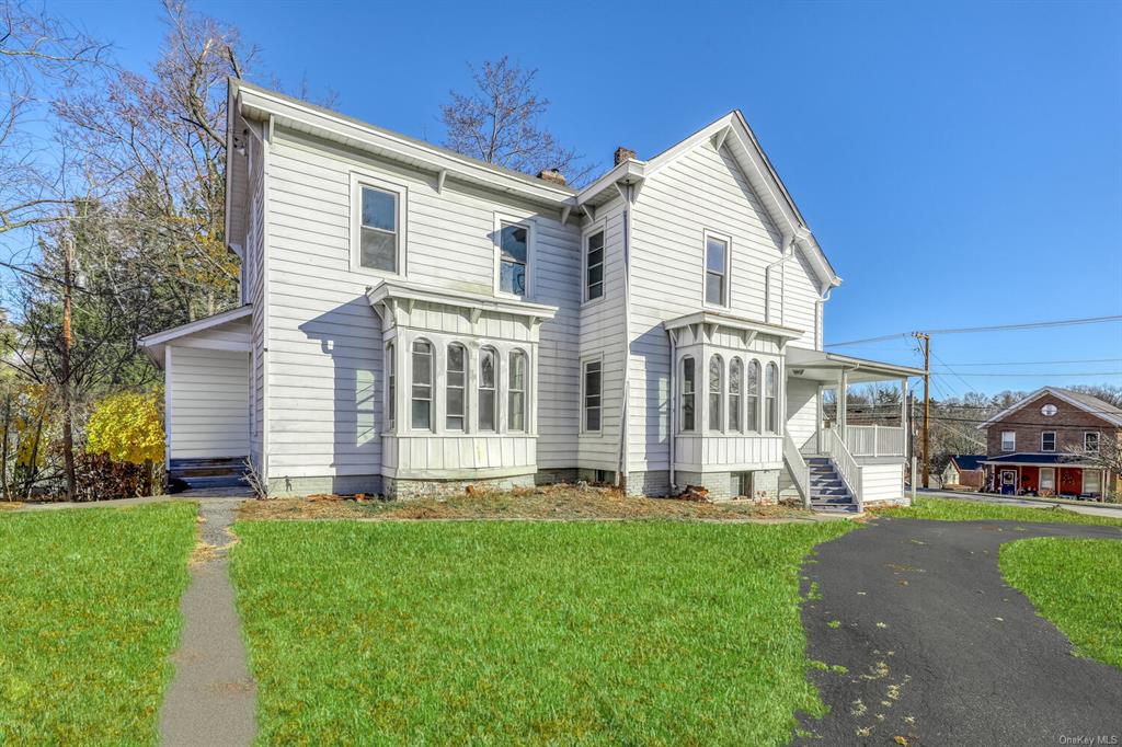 Back of property with a porch and a yard