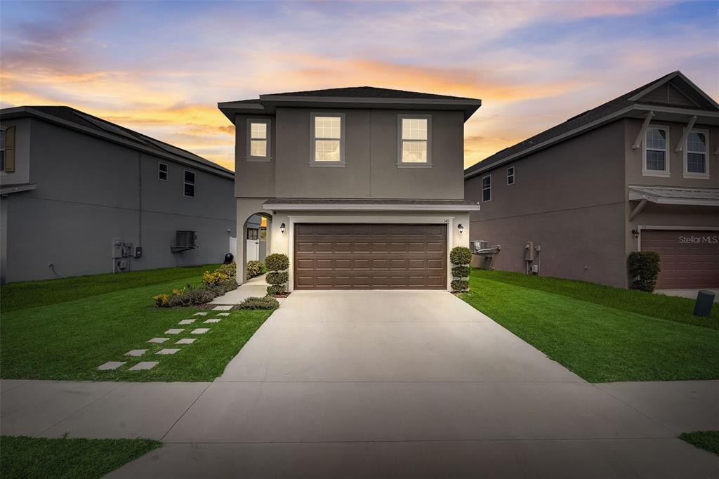 a front view of a house with a yard and garage