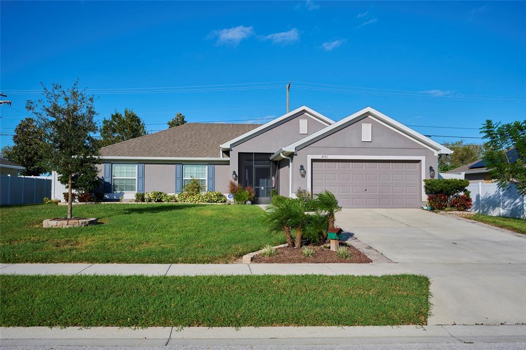 a front view of a house with a garden and yard