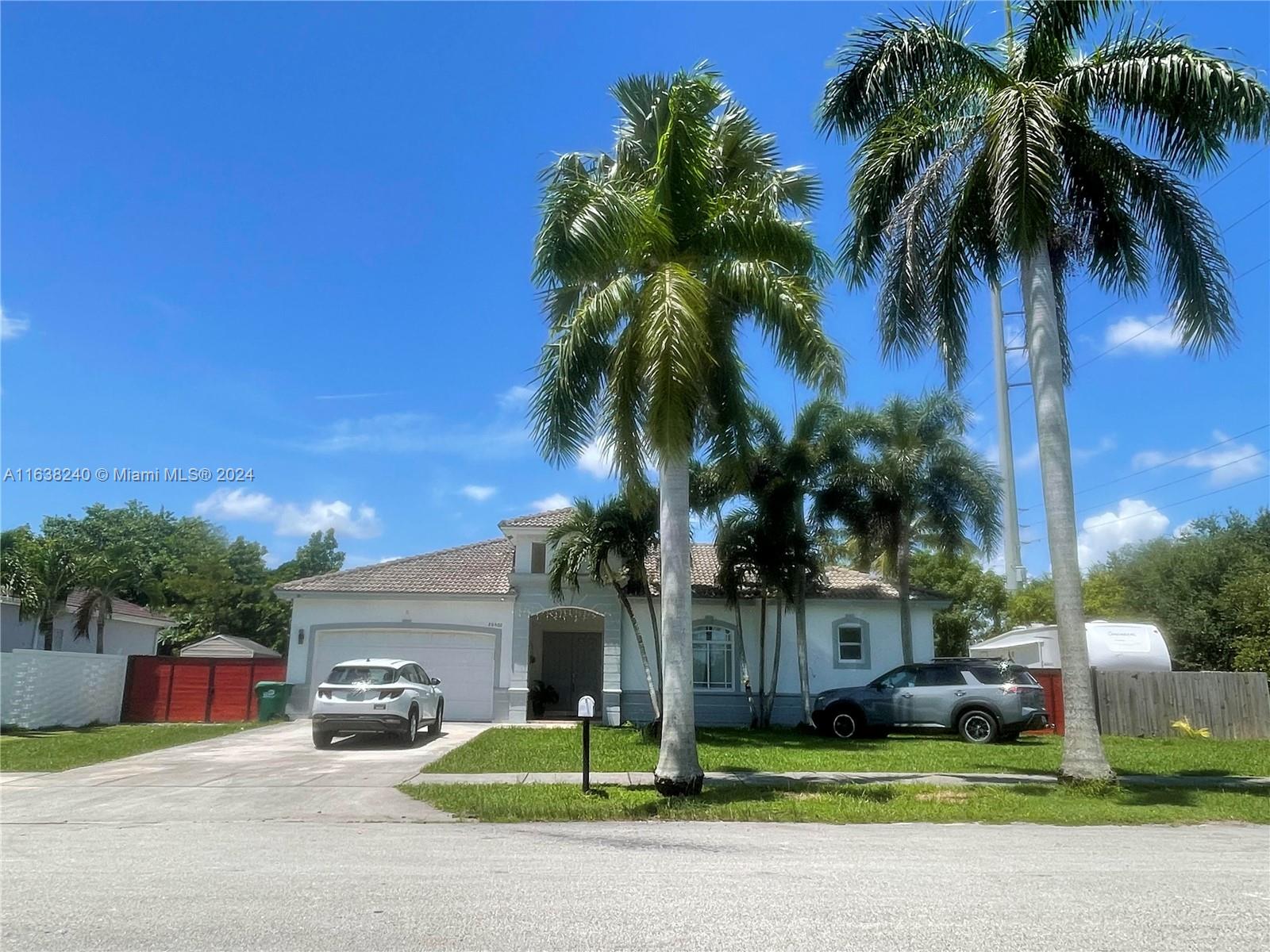 a view of a house with a yard and palm trees