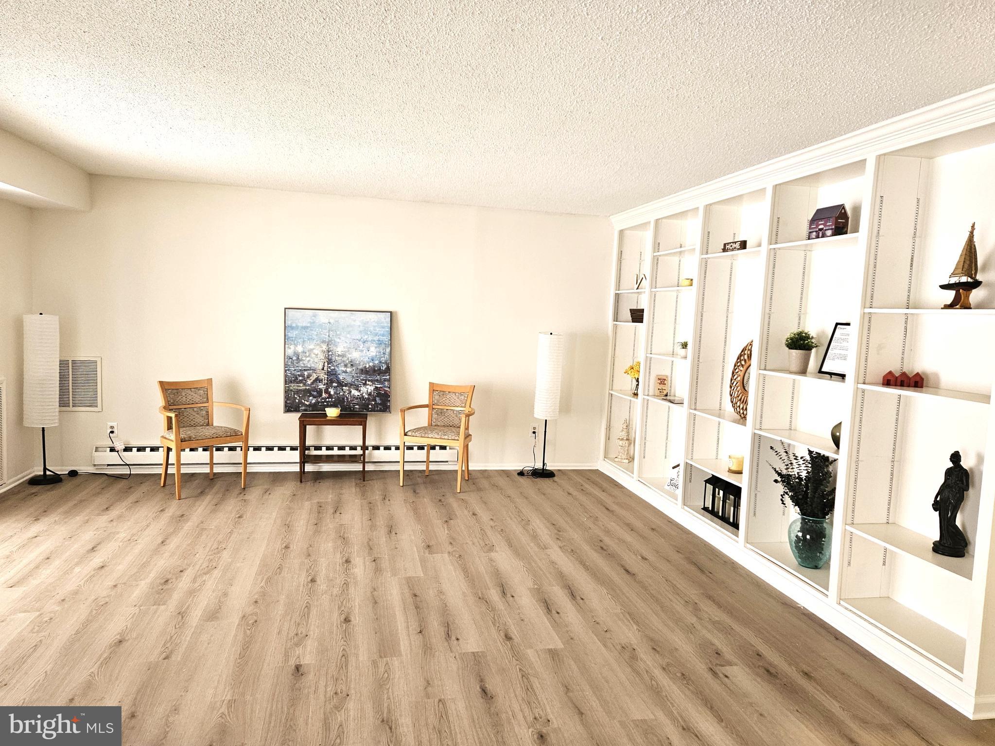 a view of a living room hardwood floor and a kitchen