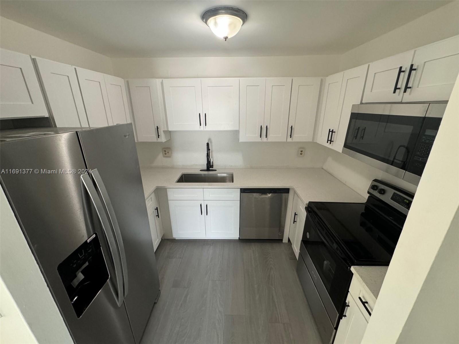 a kitchen with a sink a stove a refrigerator and cabinets