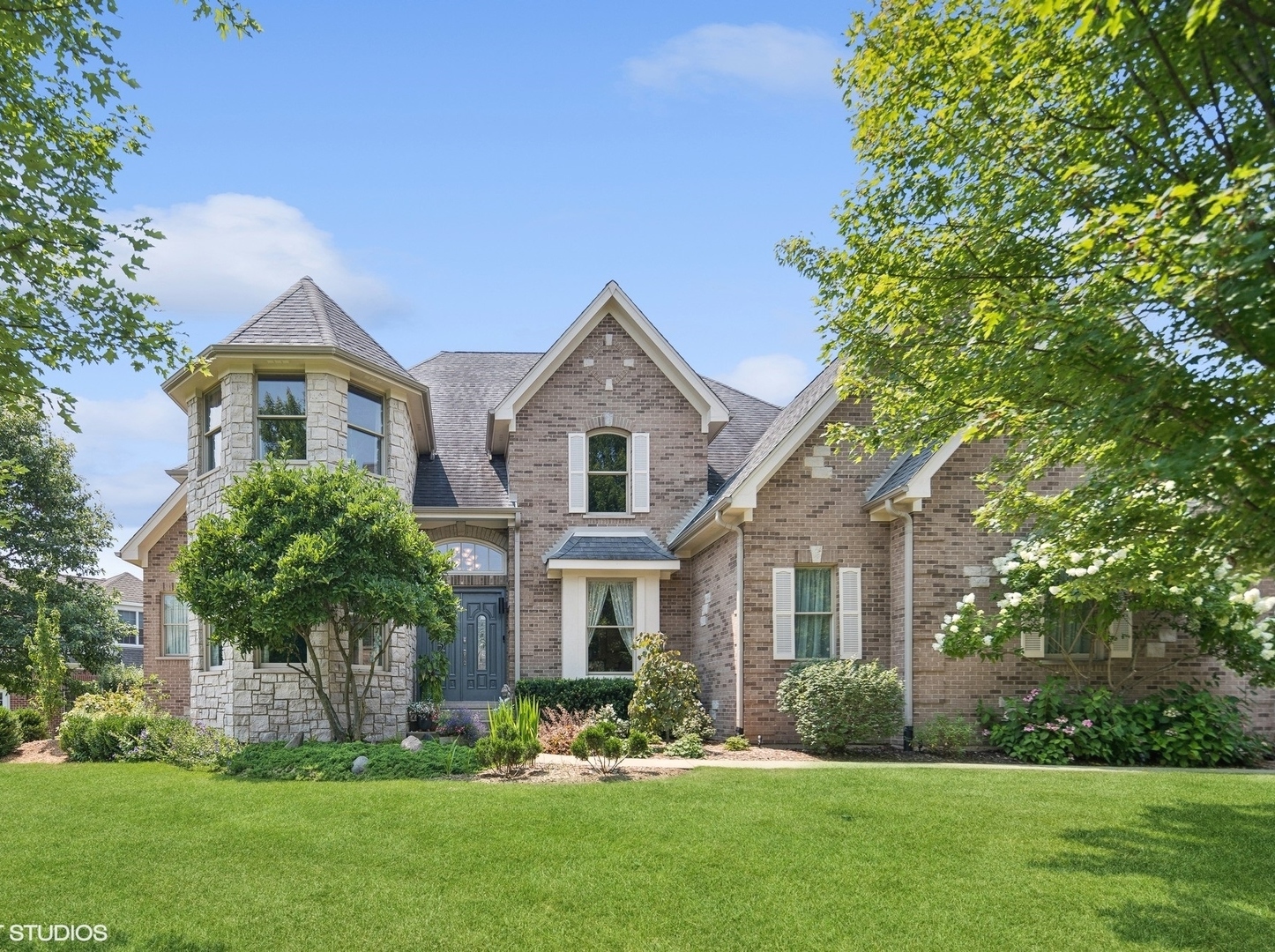 a front view of a house with a yard and trees