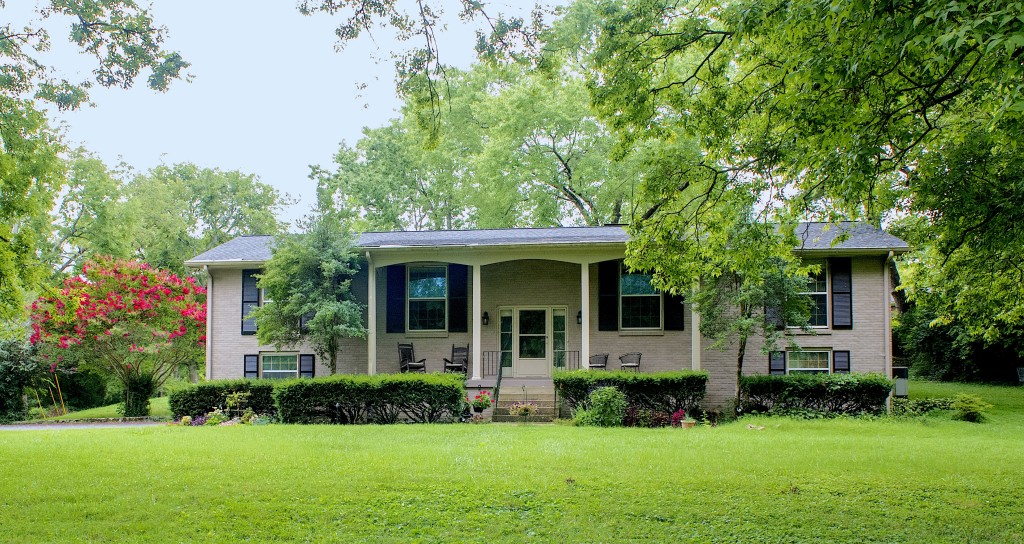 a front view of a house with a yard and potted plants