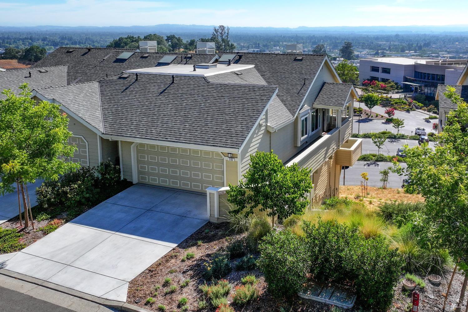 an aerial view of a house with a yard and large tree