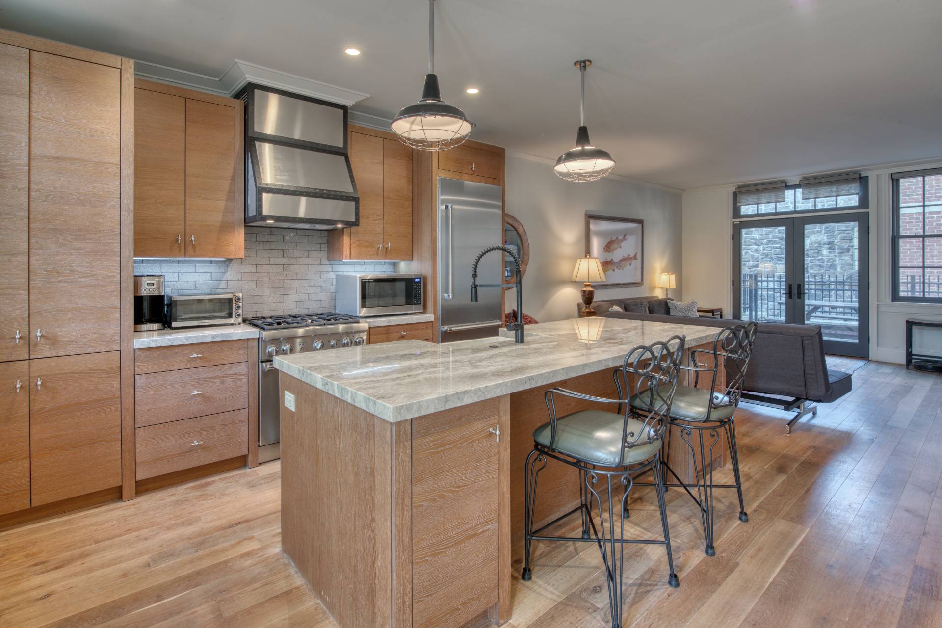 a kitchen with granite countertop a stove a sink a dining table and chairs