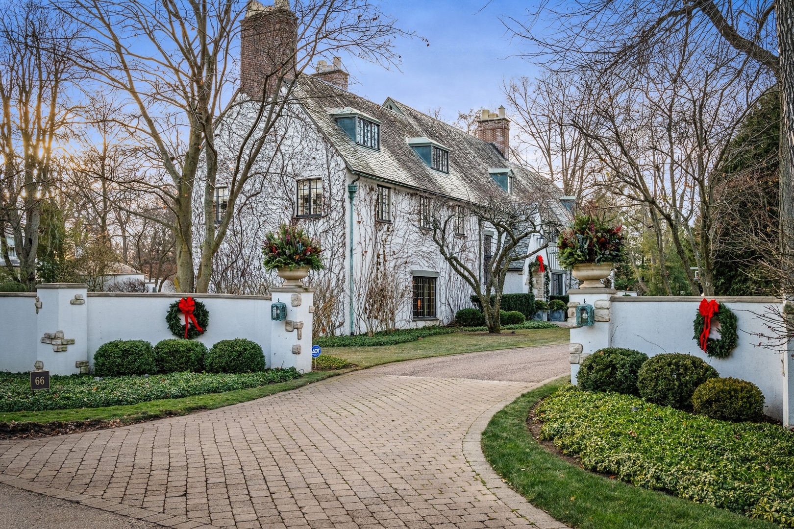 a front view of a house with a yard and potted plants