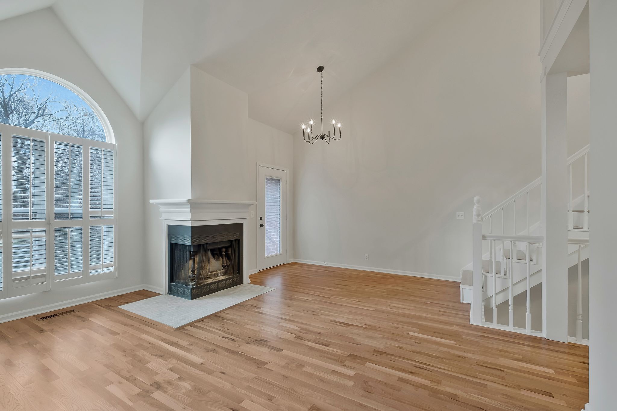 a view of a livingroom with a fireplace wooden floor and a fireplace