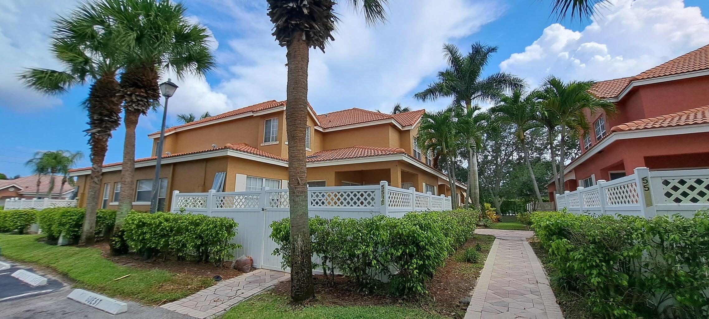 a front view of a house with a yard and potted plants