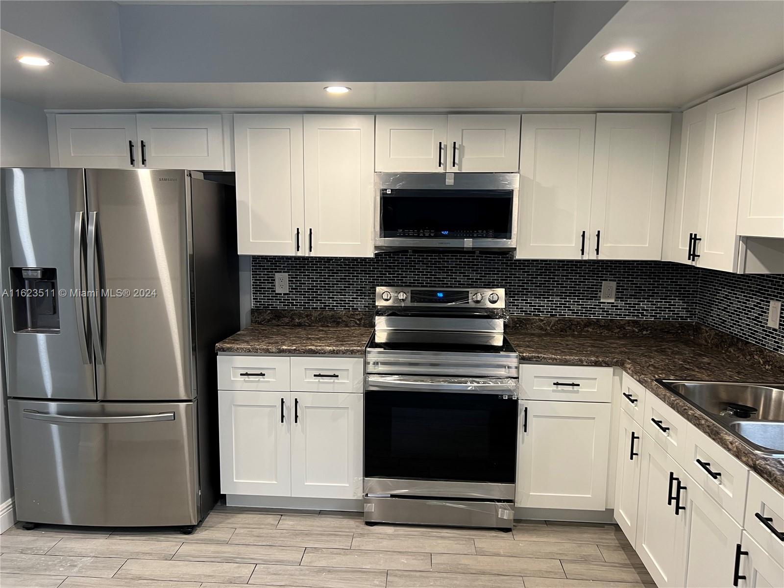 a kitchen with cabinets stainless steel appliances and a counter space