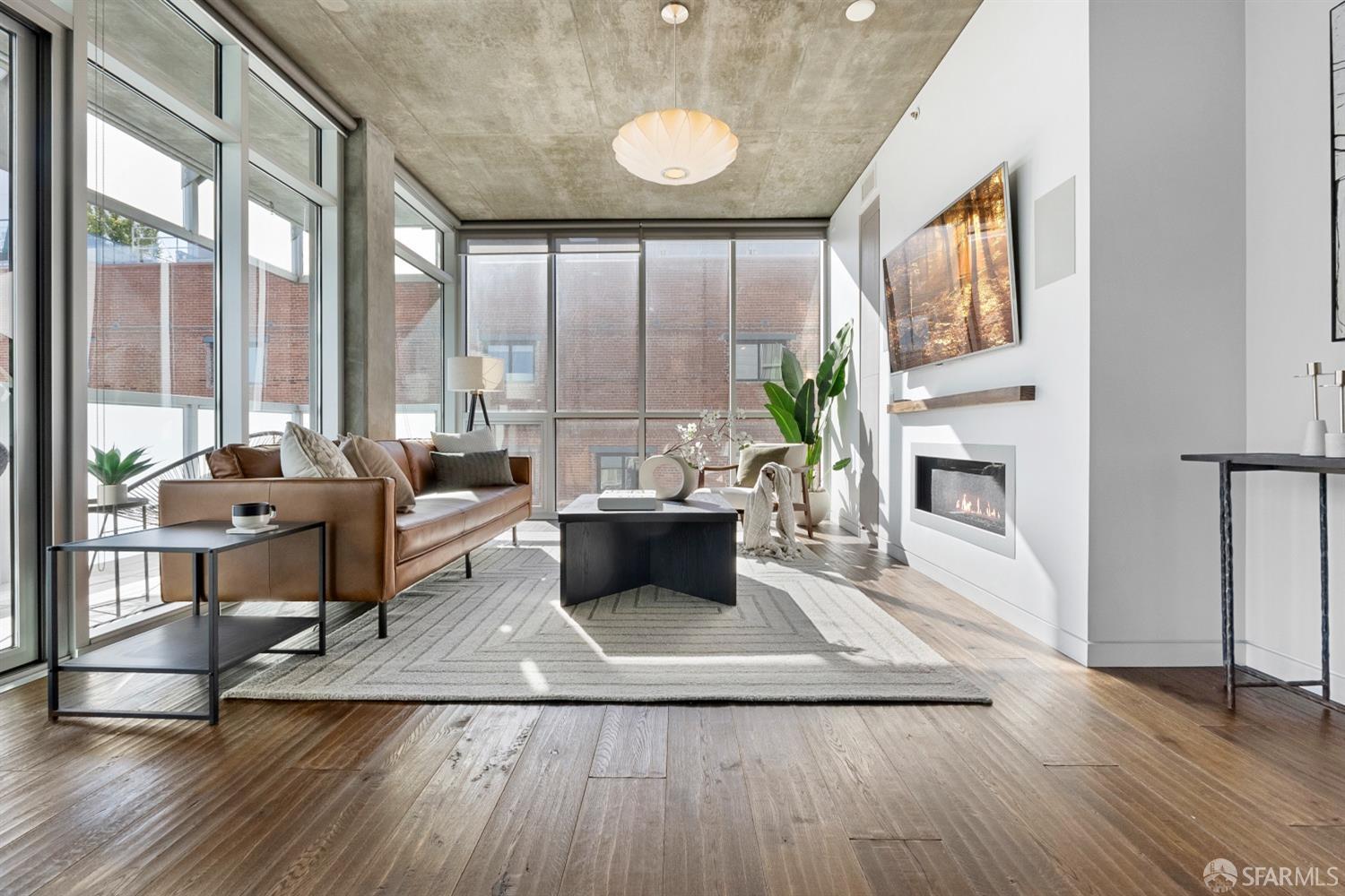 a living room with furniture large window and wooden floor