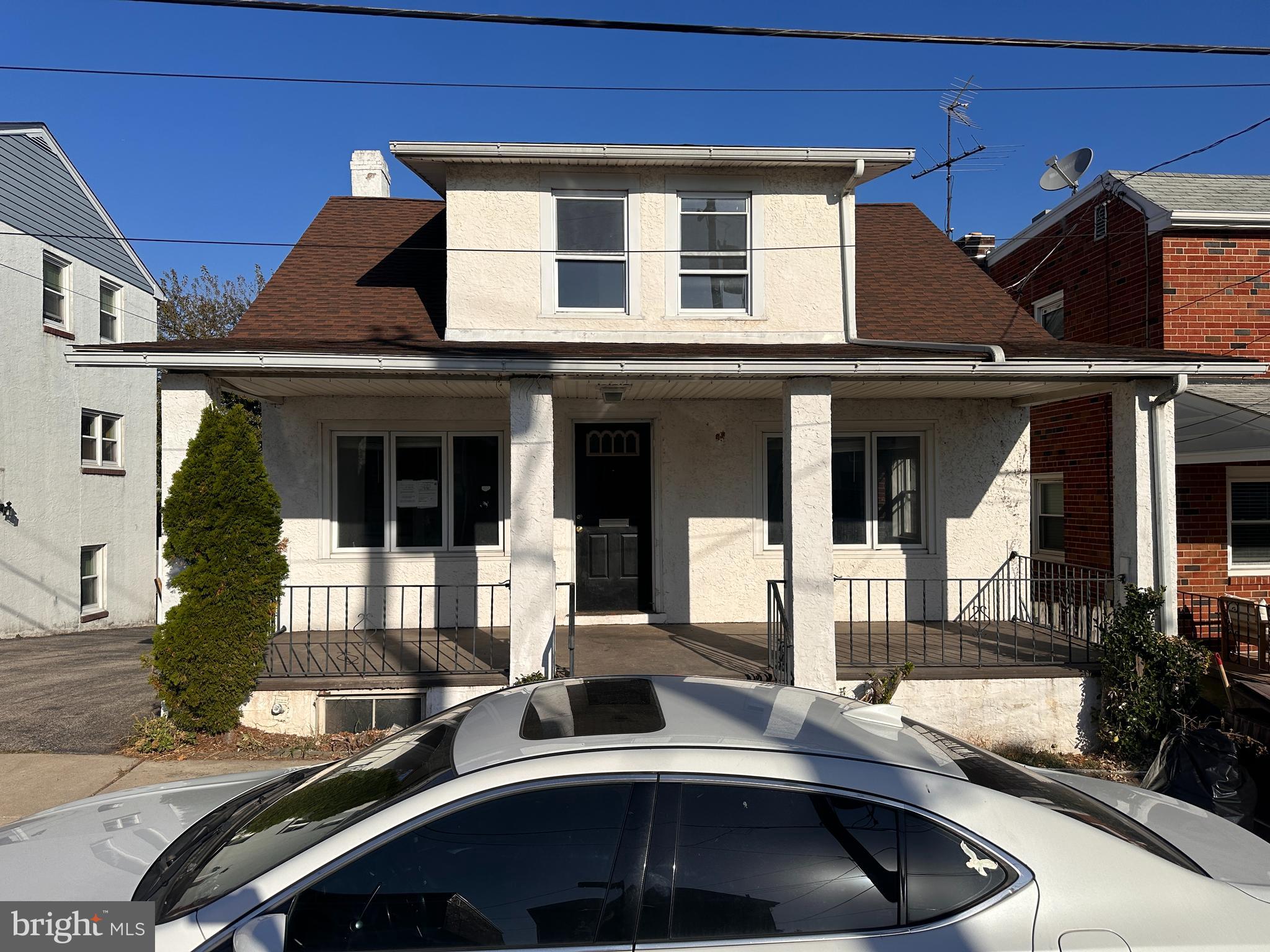 a front view of a house with cars parked