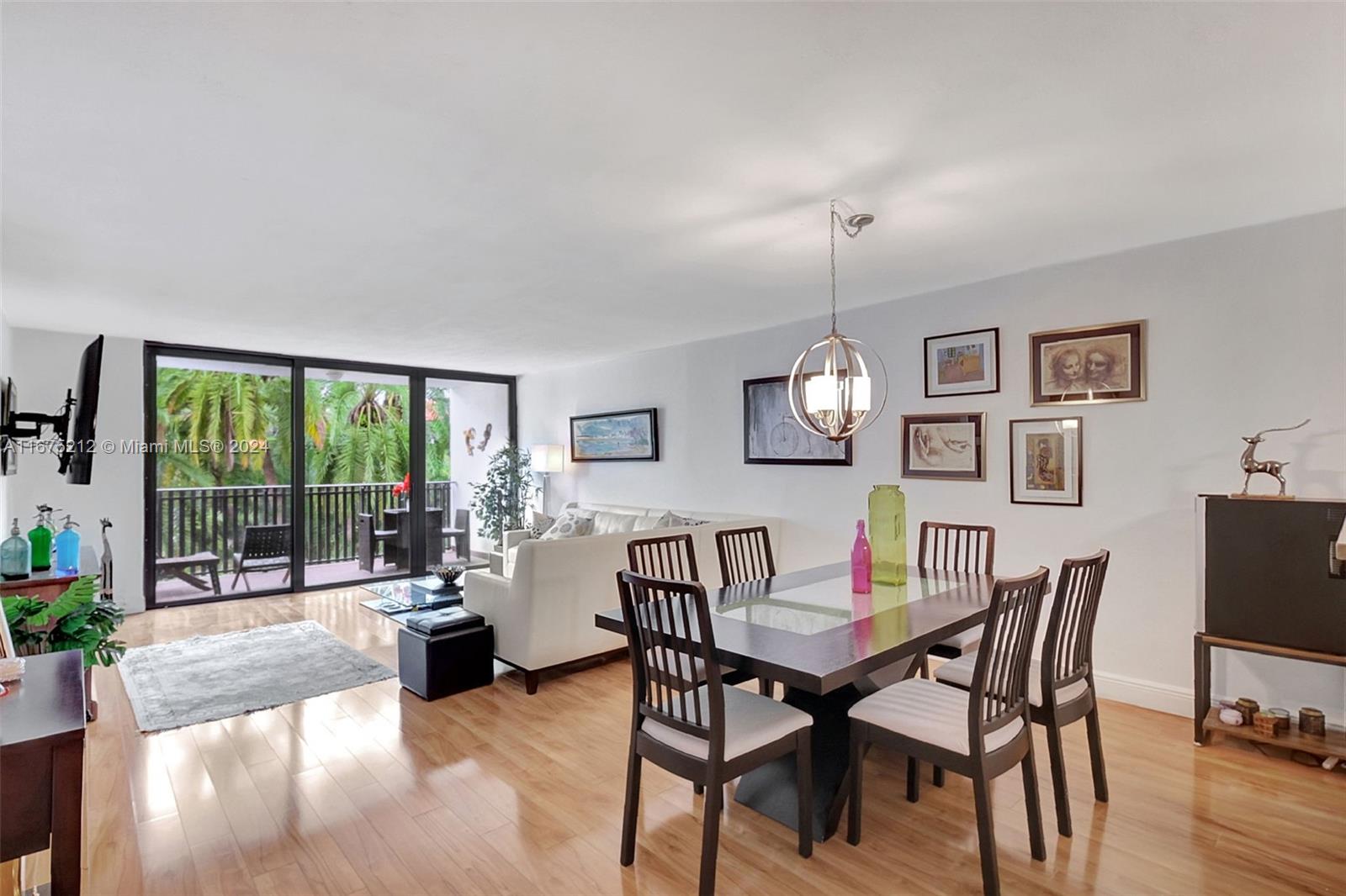 a dining room with furniture a chandelier and wooden floor