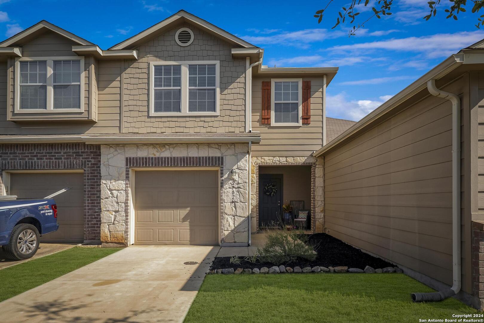 a front view of a house with a yard and garage