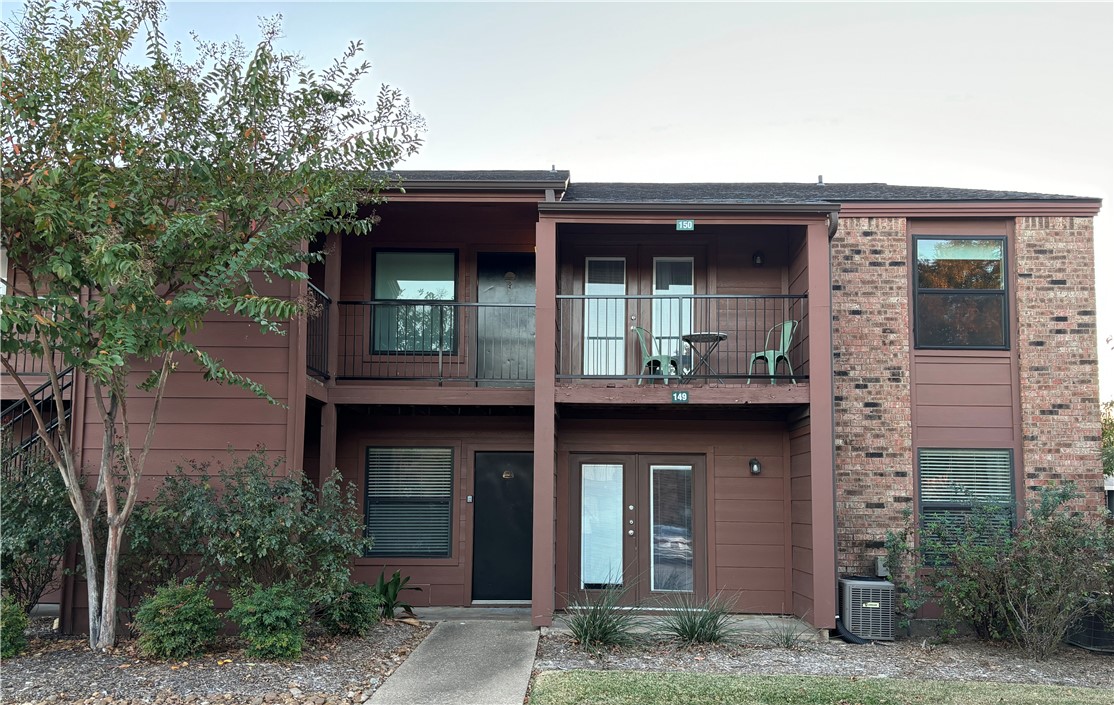 a view of a house with large windows and a small yard