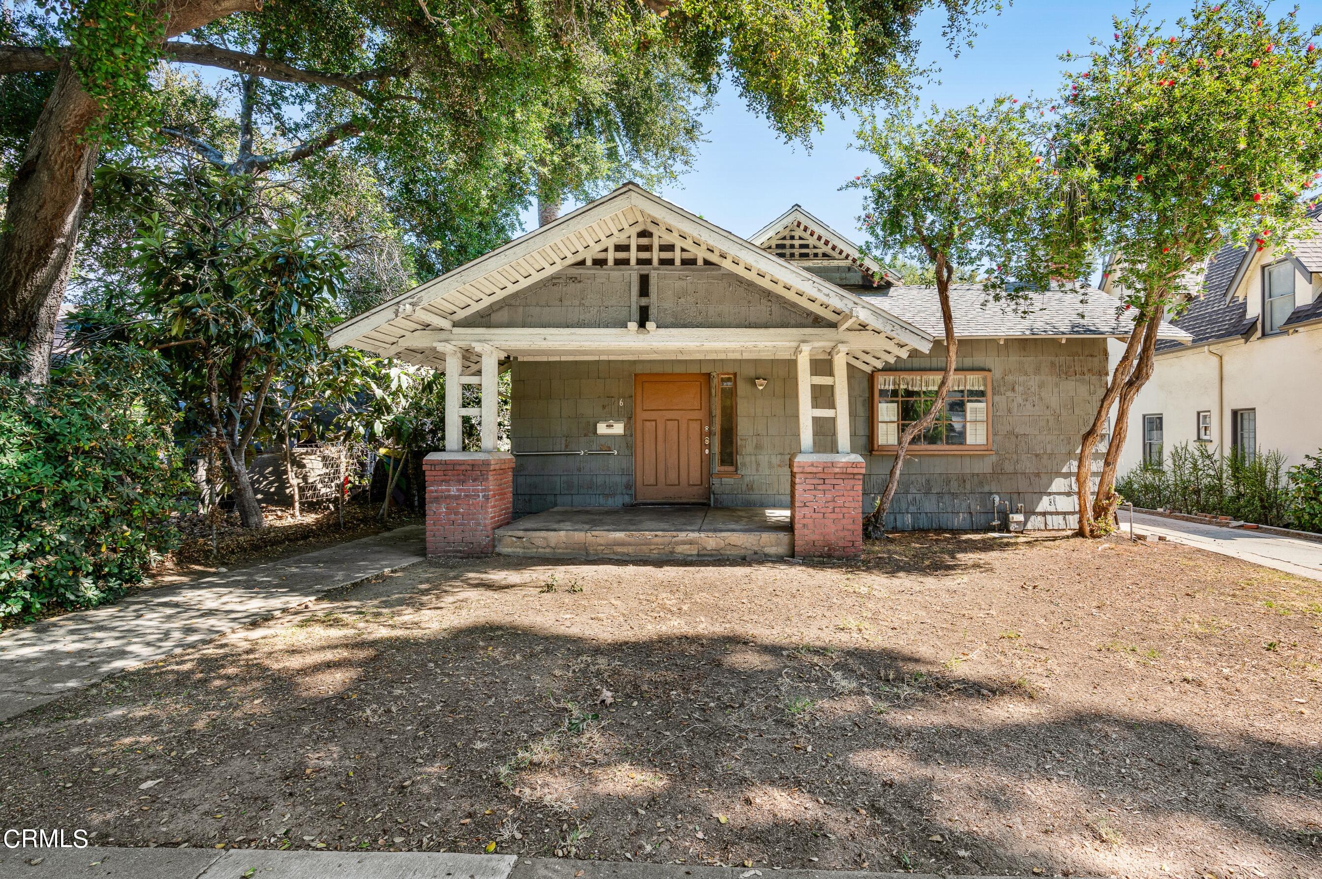 a view of a house with a yard and large tree