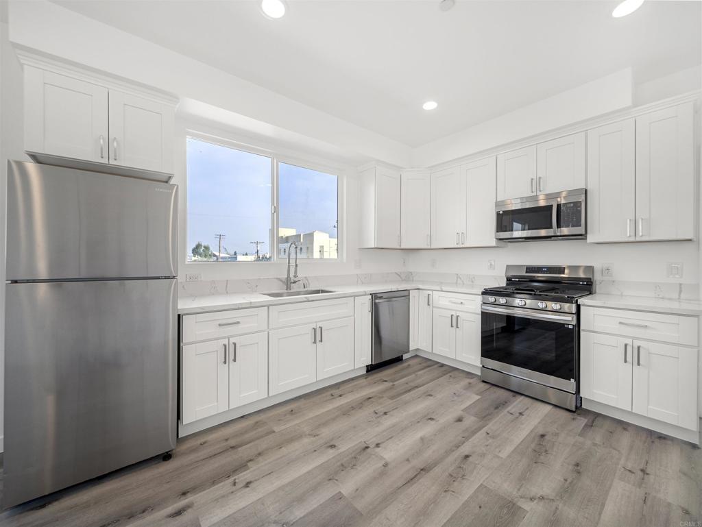 a kitchen with granite countertop white cabinets and stainless steel appliances