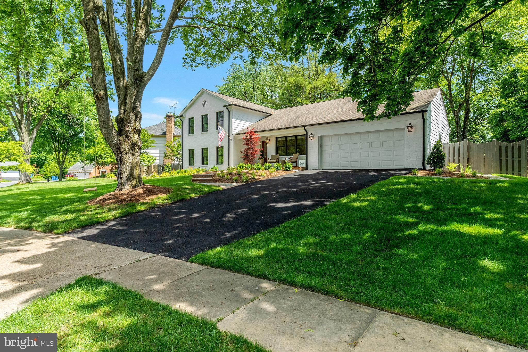 a front view of a house with a yard and trees