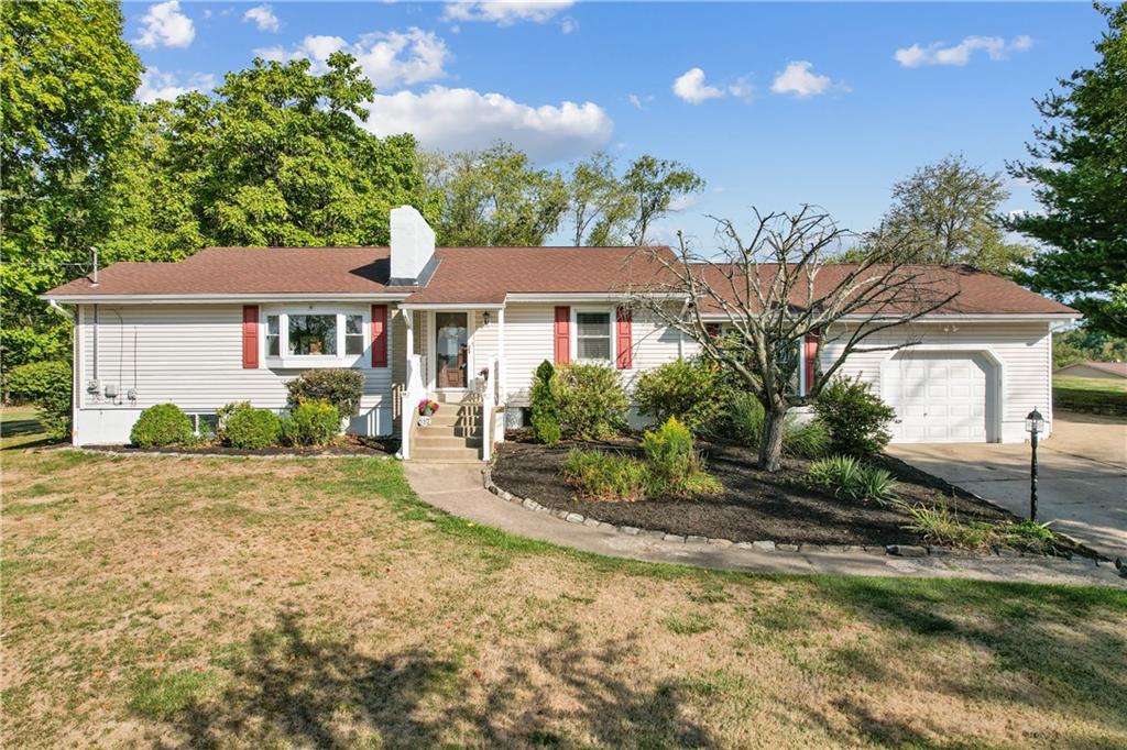 a front view of a house with a yard and potted plants