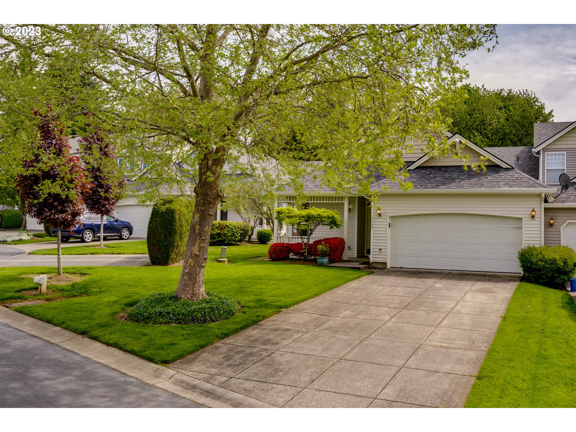 a front view of a house with a yard and trees