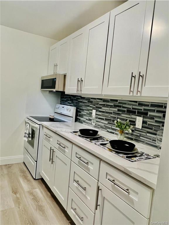 a kitchen with stainless steel appliances granite countertop a sink a stove and cabinets