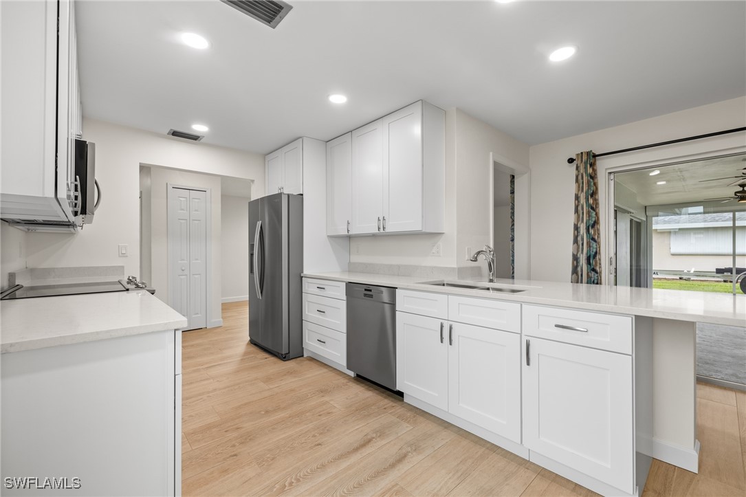 a kitchen with white cabinets and stainless steel appliances