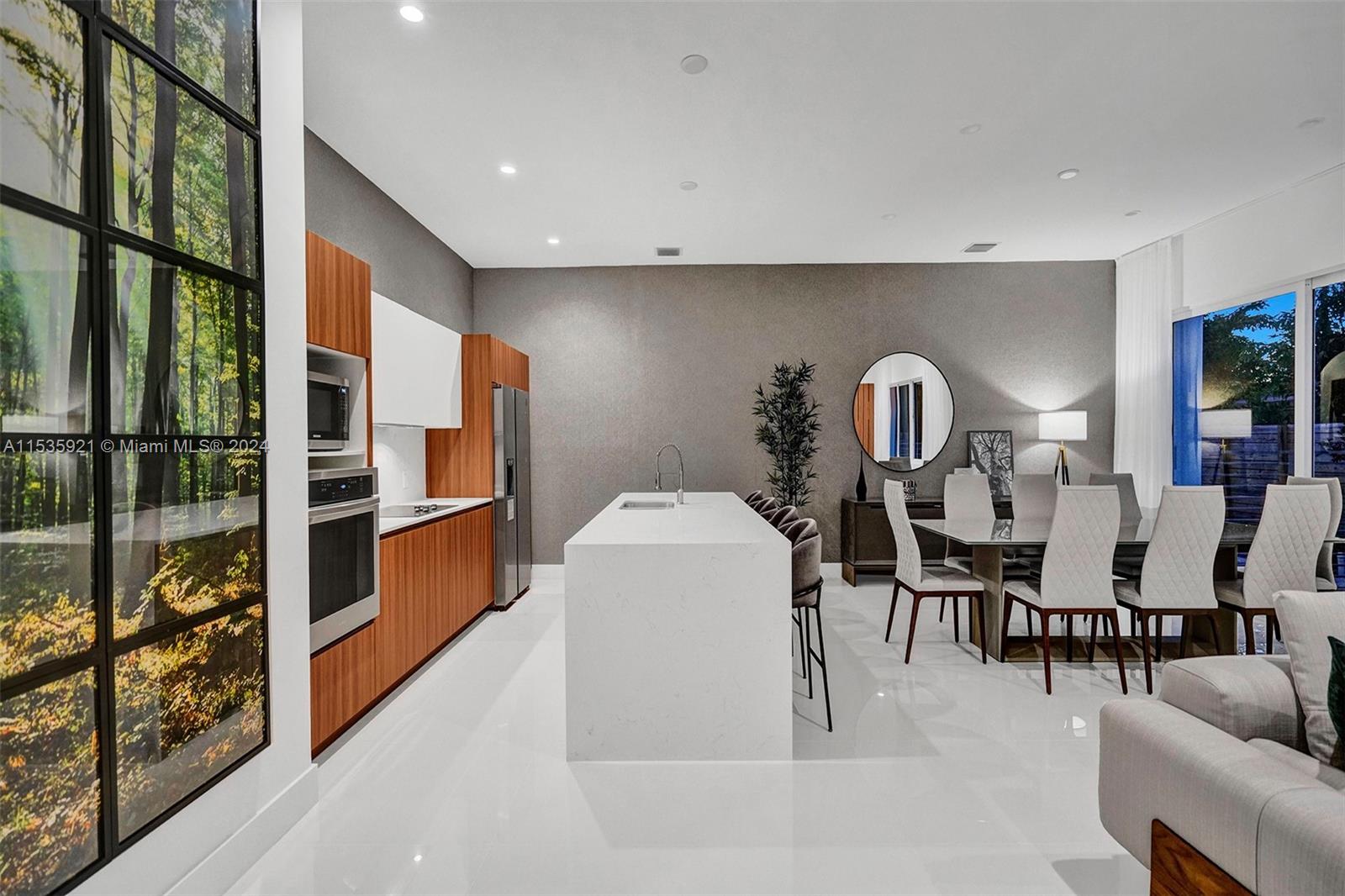 a living room with furniture a window and stainless steel appliances